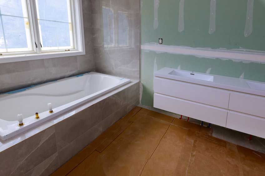 A bathtub in a bathroom receiving repairs.