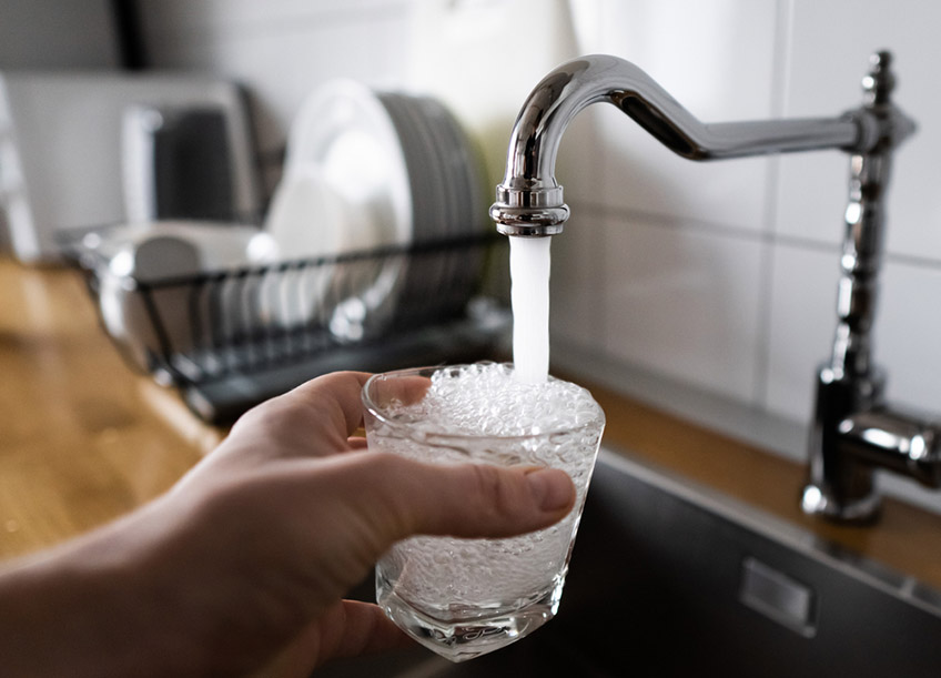 a running faucet blasting highly pressurized water