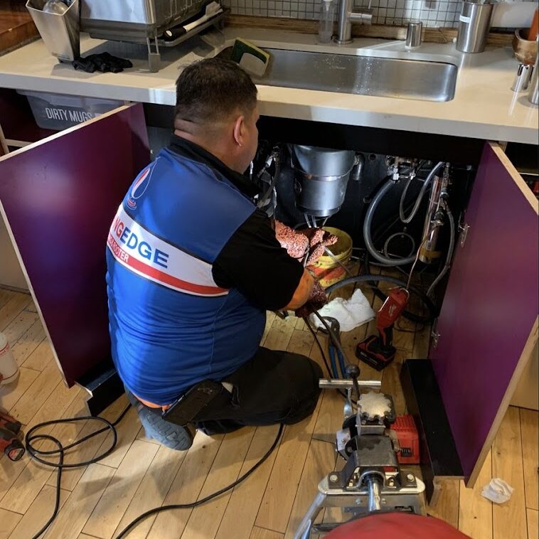 employee replacing a garbage disposal unit