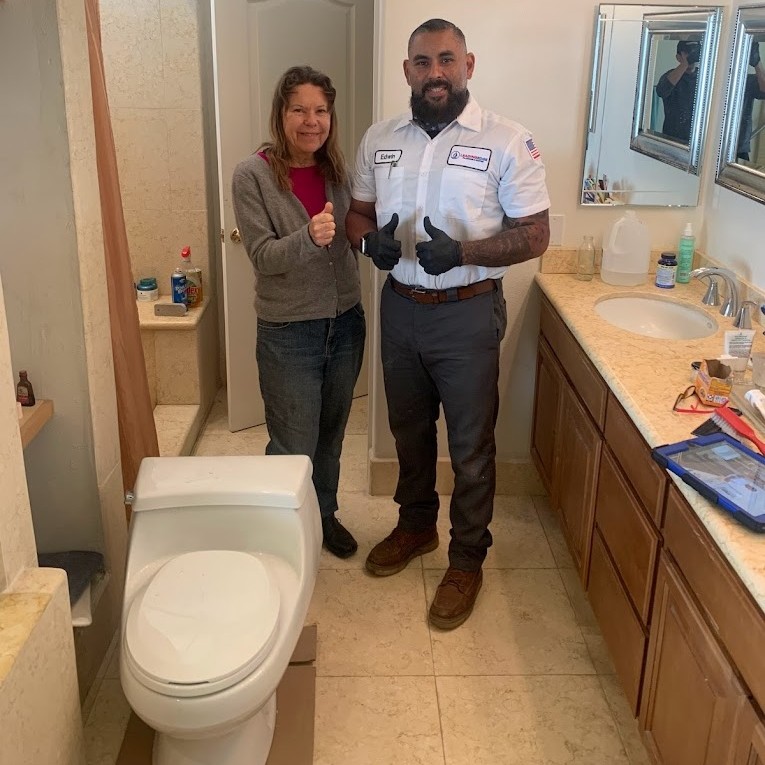 employee and happy customer next to a toilet